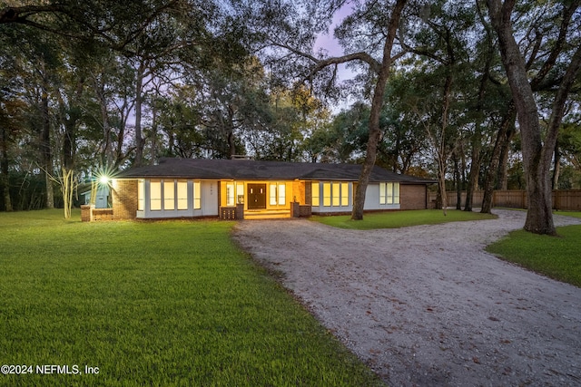 ranch-style home with a yard