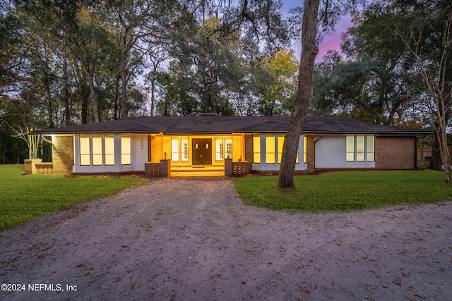 single story home featuring a lawn