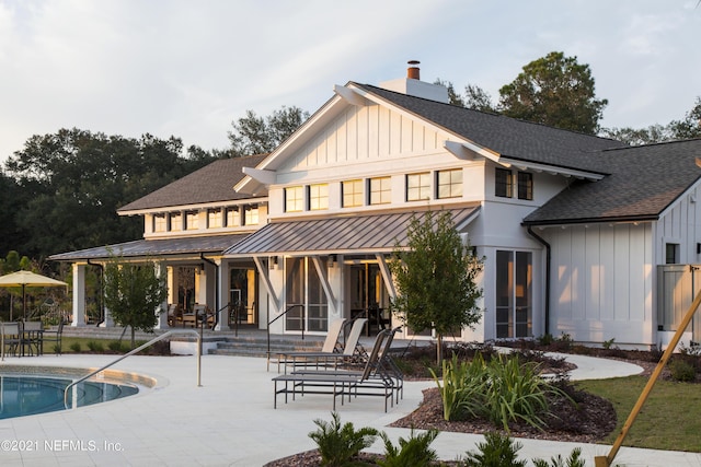 63 Bird Watch Ct, Saint Augustine, FL 32092 - back of property featuring board and batten siding, a shingled roof, a standing seam roof, and a patio area