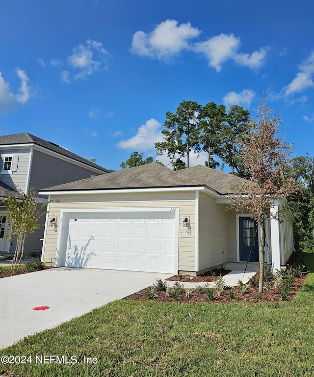 view of front of home with a front lawn and a garage