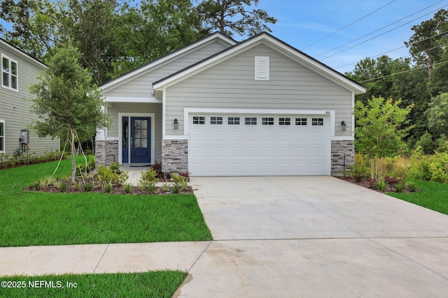 63 Bird Watch Ct, Saint Augustine, FL 32092 - view of front of property with stone siding, a front lawn, driveway, and an attached garage