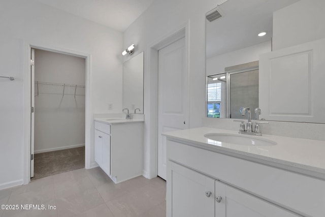 63 Bird Watch Ct, Saint Augustine, FL 32092 - full bathroom with a stall shower, two vanities, a spacious closet, tile patterned flooring, and baseboards