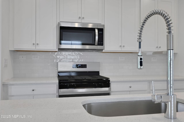 63 Bird Watch Ct, Saint Augustine, FL 32092 - kitchen featuring appliances with stainless steel finishes, white cabinets, and tasteful backsplash