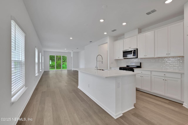 63 Bird Watch Ct, Saint Augustine, FL 32092 - kitchen featuring appliances with stainless steel finishes, a sink, light wood-style floors, tasteful backsplash, and recessed lighting