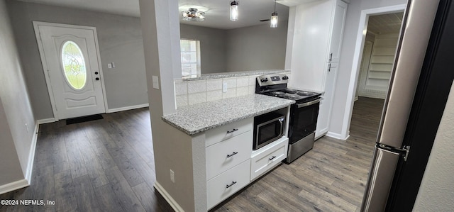 kitchen featuring a wealth of natural light, white cabinetry, stainless steel appliances, and light stone countertops