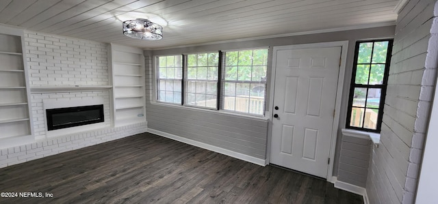 unfurnished living room featuring wood ceiling, dark wood-type flooring, a fireplace, built in features, and crown molding