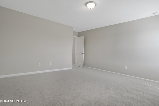 unfurnished room featuring light carpet