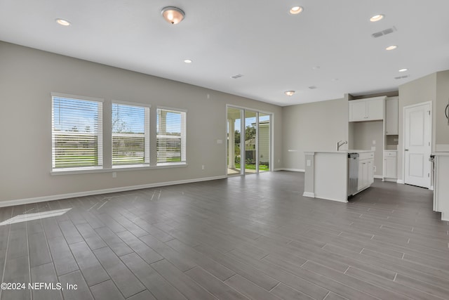 unfurnished living room with light wood-type flooring and a wealth of natural light