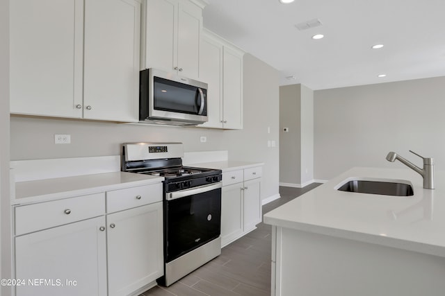 kitchen featuring white cabinets, light hardwood / wood-style floors, sink, and appliances with stainless steel finishes