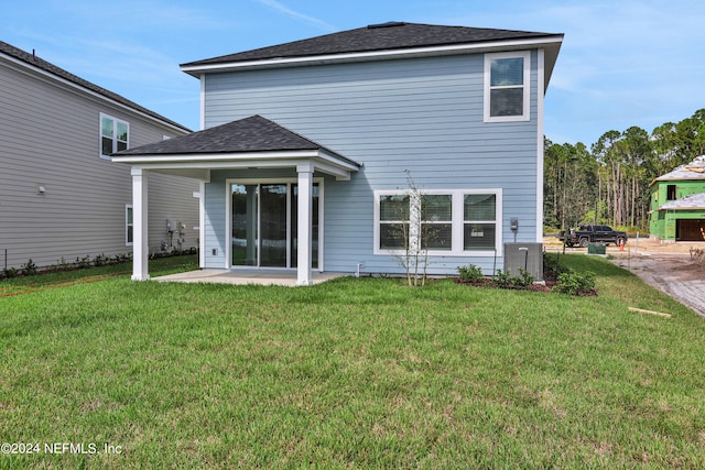 rear view of property featuring a lawn and a patio