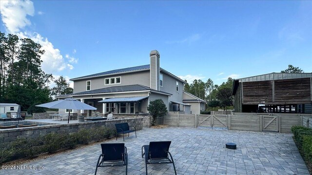 10225 Russell Sampson Rd, Saint Johns, FL 32259 - back of house with a gate, a patio, fence, a chimney, and an outdoor structure