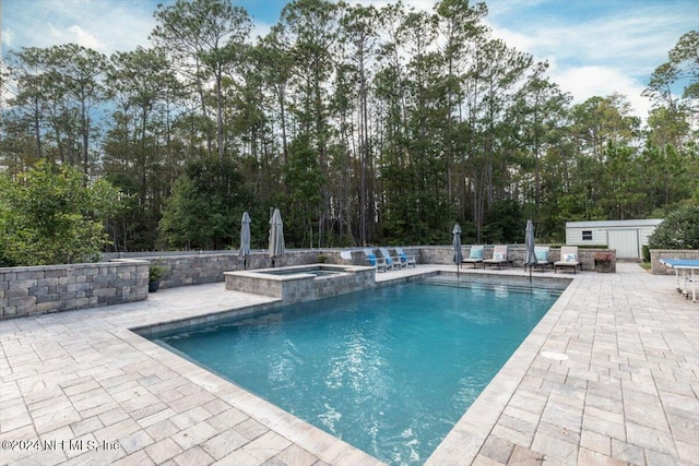 view of pool featuring an in ground hot tub and a patio