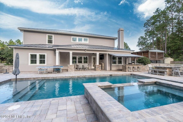 10225 Russell Sampson Rd, Saint Johns, FL 32259 - rear view of house with a standing seam roof, a patio, metal roof, outdoor dining area, and a chimney