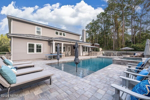 view of swimming pool featuring a patio area and an in ground hot tub