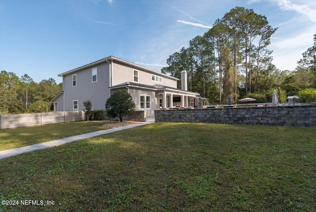 rear view of property featuring a lawn