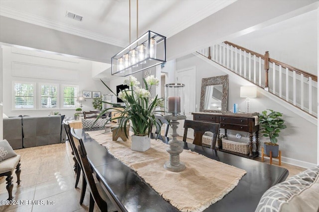 dining space featuring ornamental molding and light tile patterned floors