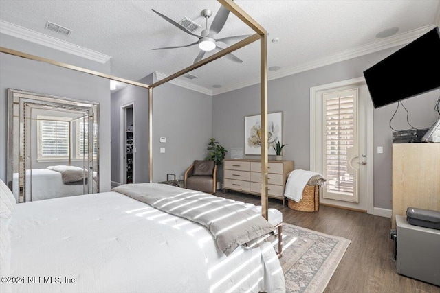 bedroom featuring ceiling fan, crown molding, a textured ceiling, and wood-type flooring