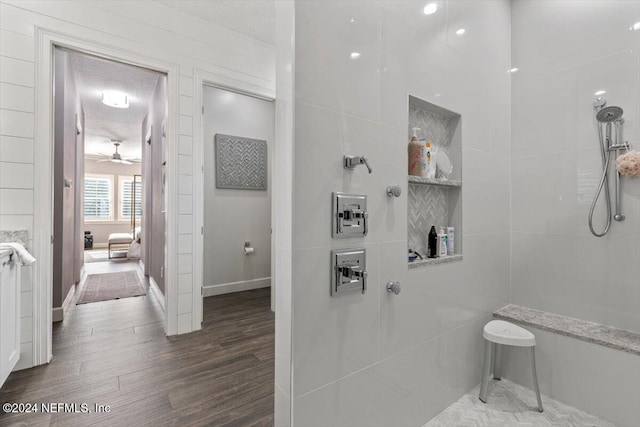 bathroom with hardwood / wood-style floors, a shower, a textured ceiling, and ceiling fan