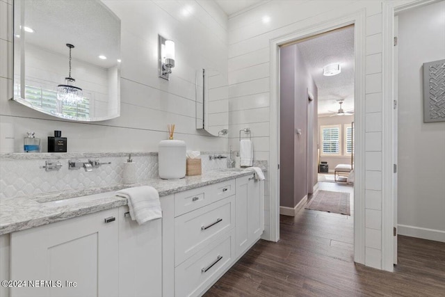 bathroom featuring vanity, a textured ceiling, hardwood / wood-style floors, and backsplash