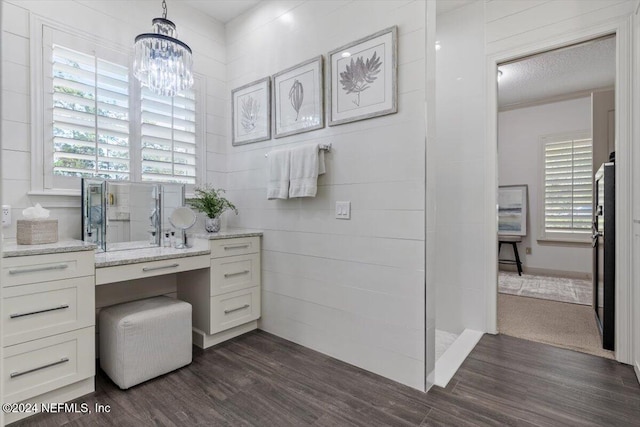 bathroom featuring wood-type flooring, a textured ceiling, walk in shower, vanity, and a chandelier