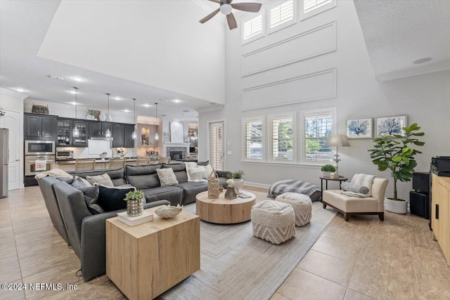 tiled living room featuring a high ceiling, crown molding, a textured ceiling, and ceiling fan