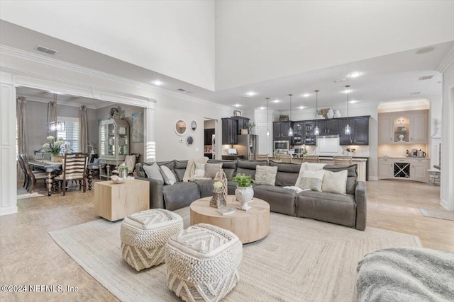 living room with crown molding and a high ceiling