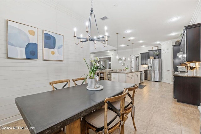 dining area featuring crown molding, sink, and light tile patterned floors