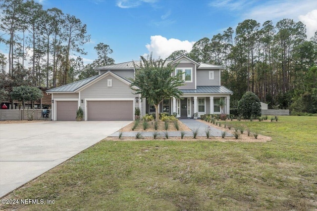 view of front of house with covered porch, a front yard, and a garage