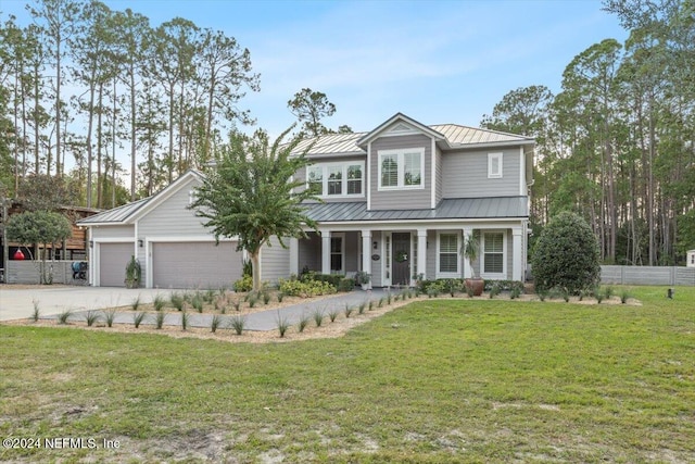 view of front of property with a front yard, covered porch, and a garage