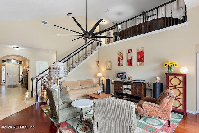 living room featuring ceiling fan, high vaulted ceiling, and wood-type flooring