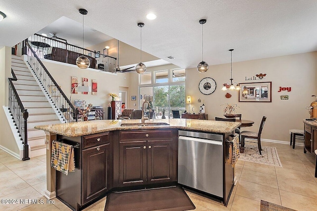 kitchen with stainless steel dishwasher, a kitchen island with sink, sink, and dark brown cabinets