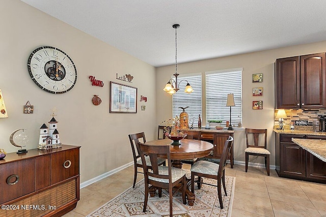 dining space with light tile patterned flooring, a notable chandelier, and a textured ceiling