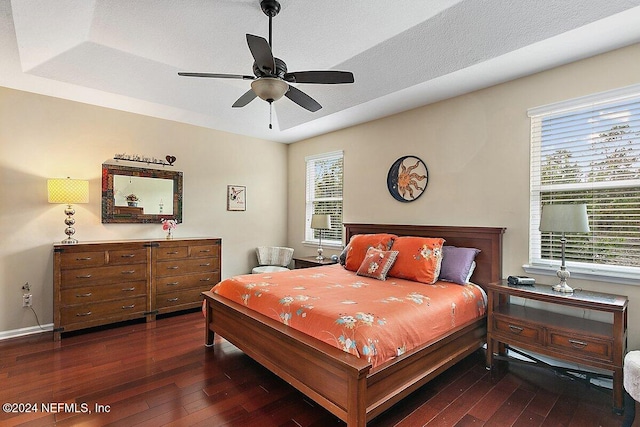 bedroom featuring multiple windows, ceiling fan, and dark hardwood / wood-style flooring