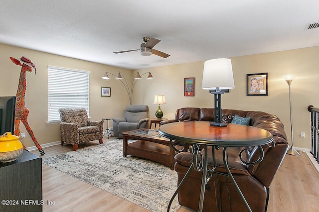 living room with light hardwood / wood-style floors and ceiling fan