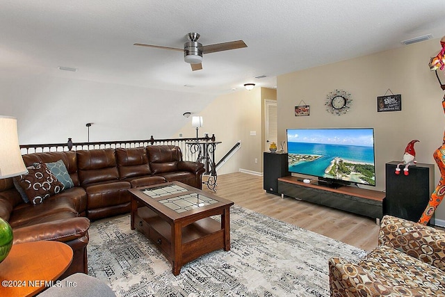 living room with a textured ceiling, wood-type flooring, and ceiling fan