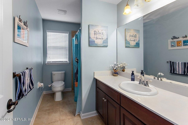 bathroom featuring vanity, toilet, and tile patterned flooring