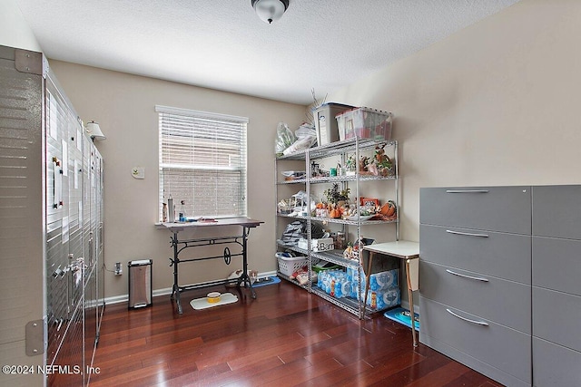 miscellaneous room featuring a textured ceiling and dark hardwood / wood-style floors