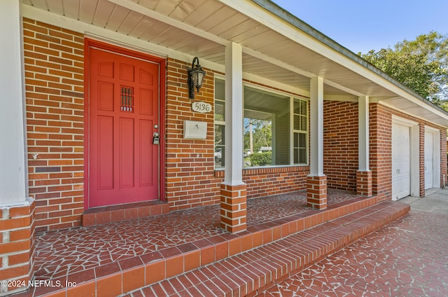 view of exterior entry featuring covered porch