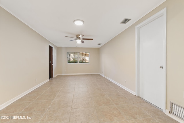 tiled empty room with ornamental molding and ceiling fan