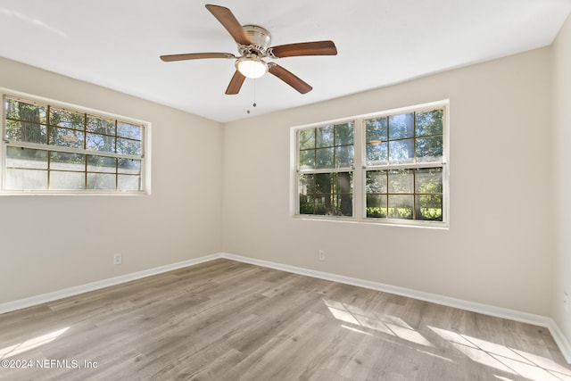 empty room with ceiling fan and light hardwood / wood-style flooring