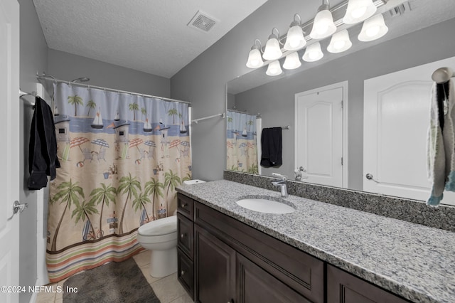 bathroom featuring a shower with shower curtain, a textured ceiling, vanity, tile patterned floors, and toilet