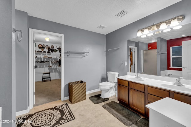 bathroom featuring vanity, walk in shower, a textured ceiling, and toilet