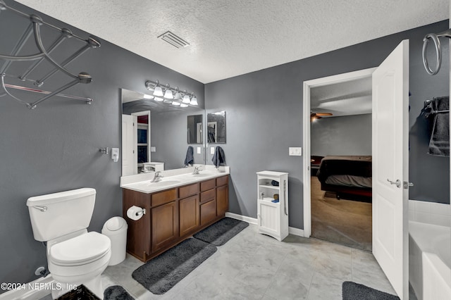 bathroom featuring a tub to relax in, a textured ceiling, ceiling fan, vanity, and toilet