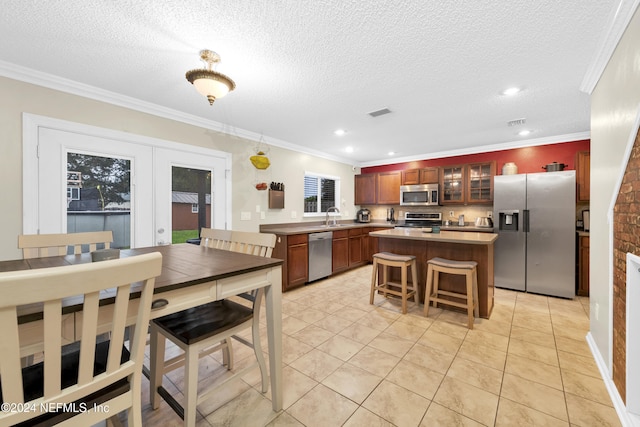 kitchen featuring a kitchen island, a kitchen bar, crown molding, and stainless steel appliances