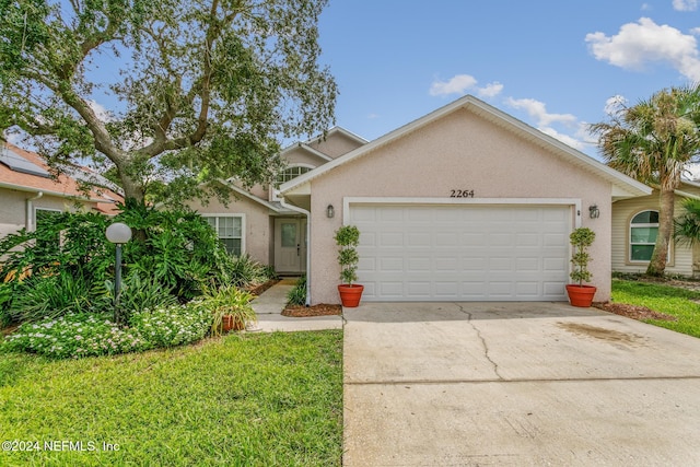 view of front of property featuring a front lawn and a garage