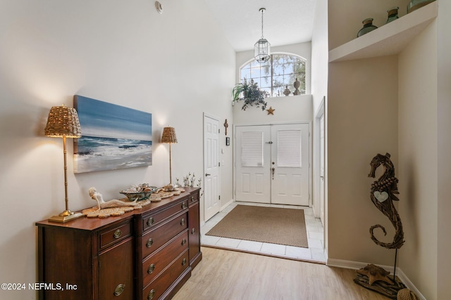 foyer entrance featuring light hardwood / wood-style floors and a high ceiling