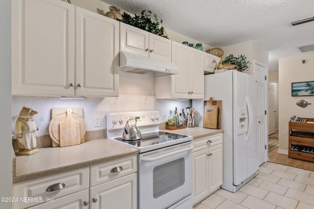 kitchen featuring backsplash, light wood-type flooring, white cabinets, a textured ceiling, and white appliances