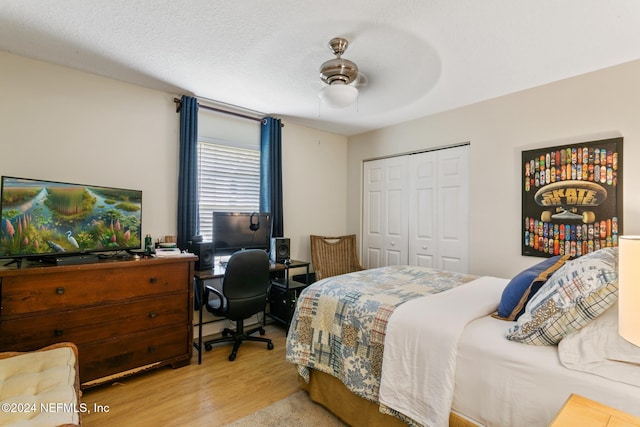 bedroom featuring a closet, a textured ceiling, light wood-type flooring, and ceiling fan