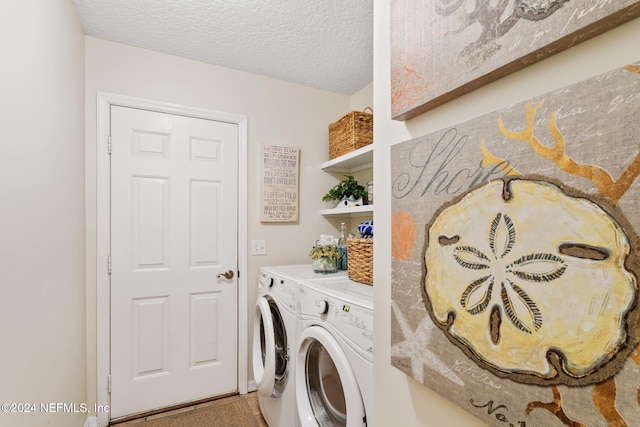 clothes washing area with a textured ceiling and washing machine and dryer