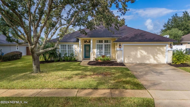 ranch-style home featuring a garage and a front lawn